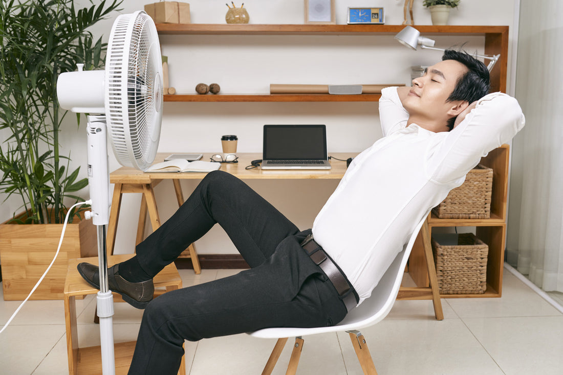 Man enjoying a portable cooling fan at home
